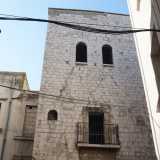 ...due ai piani superiori sormontate da archi lunati a tutto sesto e una al primo piano che si sporge su un balconcino in muratura dalla ringhiera in ferro